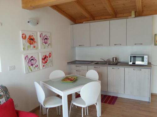a kitchen with a white table and white chairs at Residence Il Poggio in Dorio
