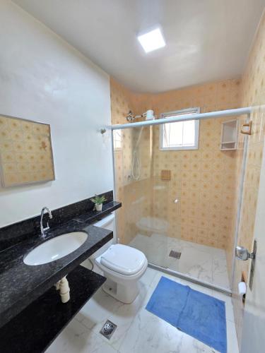 a bathroom with a sink and a toilet and a shower at Praia Morro Katia apartamentos - Edificio Franklin Storck in Guarapari