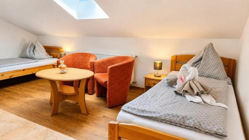 a bedroom with a bed and a chair and a table at Vila Harmónia in Turčianske Teplice