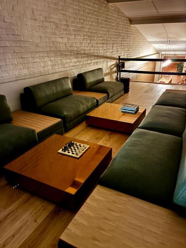 a living room with green couches and a chessboard on a table at Albi's Sandvig Boutique Hotel in Sandvig