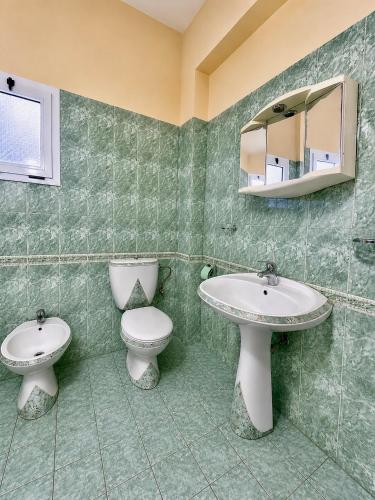 a bathroom with a toilet and a sink and a mirror at Vila New Ksamil in Ksamil