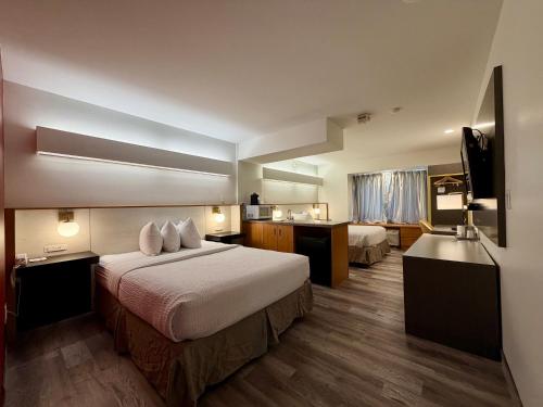 a hotel room with two beds and a bathroom at Ramada Limited Bloomington IL I-74/I-55 in Bloomington
