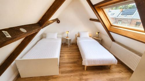 two beds in a attic with a window at Mons 21C in Mons