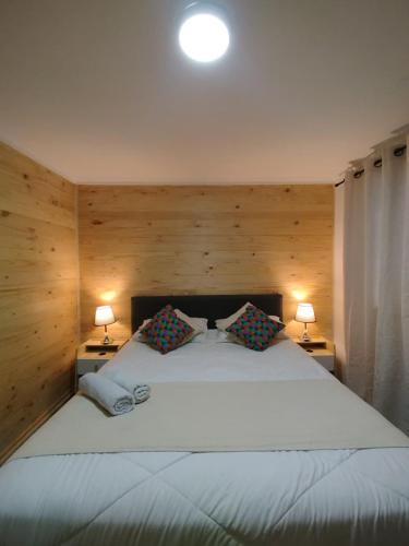 a bedroom with a large white bed with two lamps at Casa Marina Sotomayor in Santiago