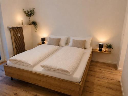 a large bed with white sheets and pillows on it at Apartment Torggl Alpenblick in Coldrano