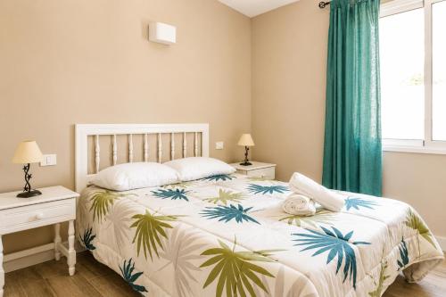 a bedroom with a bed with a palm tree bedspread at La Casita del Sur, Abades in Abades