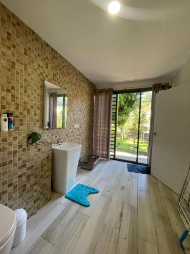 a bathroom with a tub and a sink at Tahiti Green Lodge in Punaauia