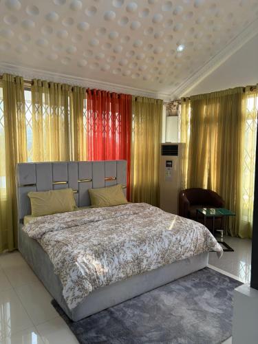 a bedroom with a large bed in a room with curtains at Nyaniba Villa in Accra