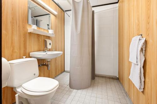 a bathroom with a toilet and a sink at Ørnes Hotell in Ørnes