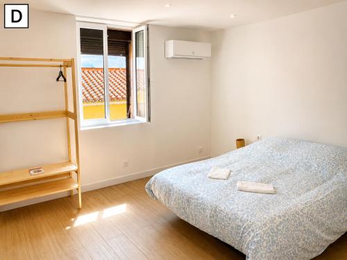 a bedroom with a bed with two towels on it at Notre Dame in Perpignan
