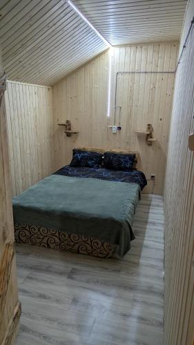 a bedroom with a bed in a wooden room at Байк Пост Т67 in Voznesensk