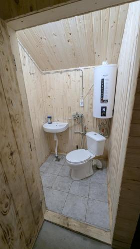 a wooden bathroom with a toilet and a sink at Байк Пост Т67 in Voznesensk