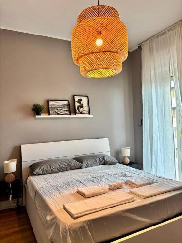 a bedroom with a large bed with a chandelier at BradAmare Seafront in Montesilvano
