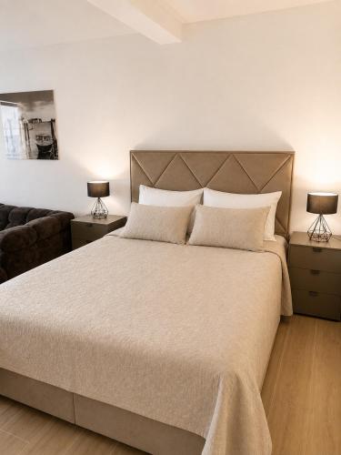 a bedroom with a large bed and two lamps at Panorama Chill in Rafailovici