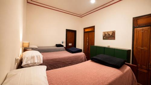 a room with three beds in a room at A la Gurda Hostel - Barrio Norte in San Miguel de Tucumán