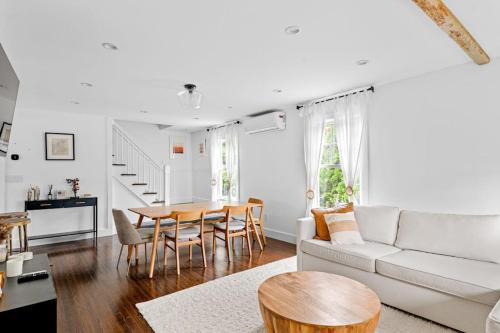 a living room with a white couch and a table at Cozy Greenport Cottage in Greenport