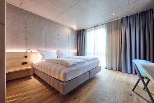 ein Schlafzimmer mit einem Bett und einem großen Fenster in der Unterkunft Belsers Hotel in Nürtingen