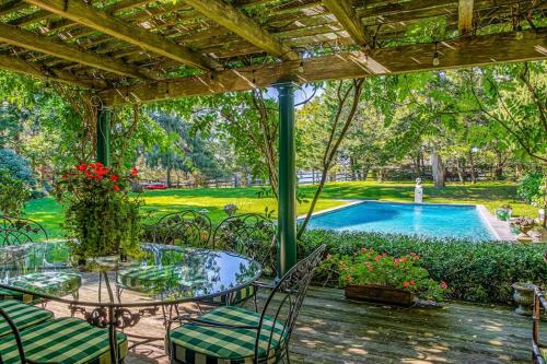 a patio with a table and chairs and a swimming pool at Cedar Crest Retreat in Southampton