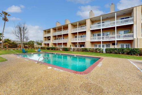 a hotel with a swimming pool in front of a building at Mariner Village 108 in Seabrook