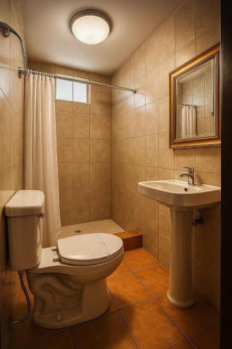 a bathroom with a toilet and a sink at Hotel Verona in San Pedro Sula