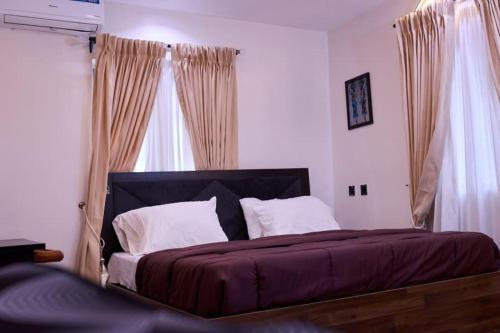 ein Schlafzimmer mit einem großen Bett und Vorhängen in der Unterkunft Treasureblue in Suberu Oje