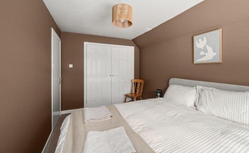 a bedroom with a white bed and a chair at Home in Perth and Kinross in Coupar Angus