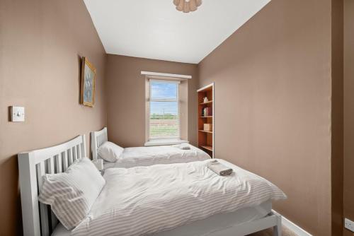two twin beds in a room with a window at Home in Perth and Kinross in Coupar Angus