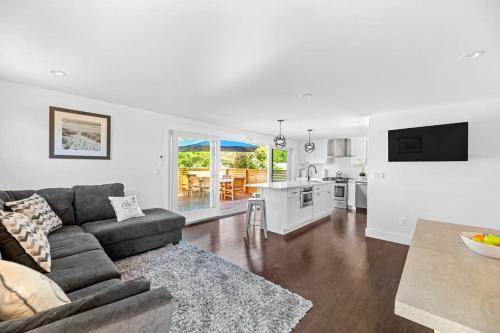a living room with a couch and a kitchen at Poolside Chic by the Sea in Ocean Bay Park