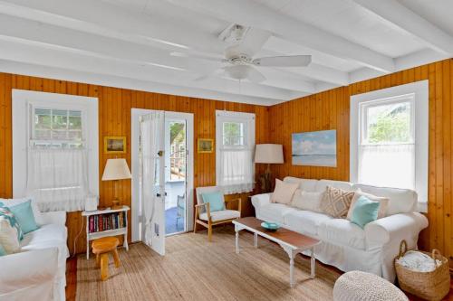 a living room with a white couch and wooden walls at Seaclusion Gardens in Ocean Beach