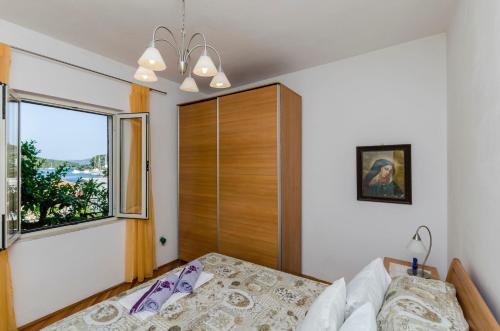 a bedroom with a bed and a window at Rooms Roza in Vrboska
