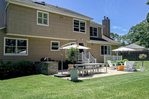 a house with a patio with a table and chairs at Hamptons Hideaway in Hampton Bays