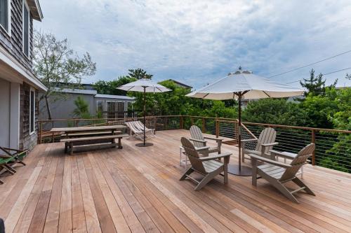 a deck with benches and umbrellas on a house at Seaside Escape on Huron in Ocean Beach