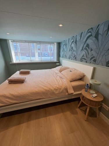 a bedroom with a large bed and a table at Salty dunes in Noordwijk