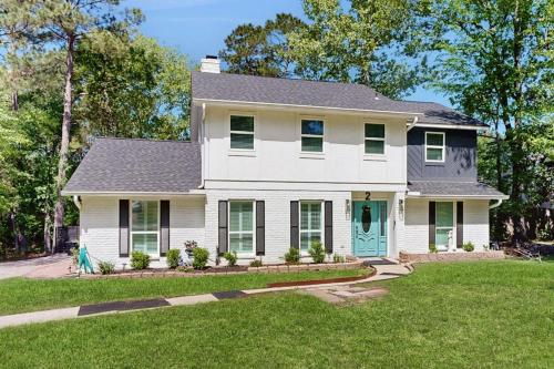 a white house with a green door on a yard at Lake Grove Retreat in Conroe