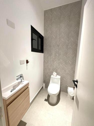 a bathroom with a toilet and a sink at Beachfront Paradise - Huge Pool, Ocean View & Surf in Cabarete