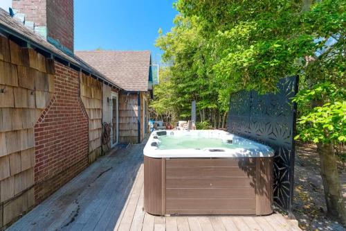 a hot tub on a deck next to a house at 15 Seneca in Ocean Bay Park