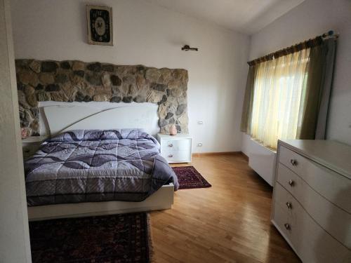 a bedroom with a bed and a stone wall at Il Pozzo dei desideri Shabby in Spilimbergo