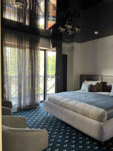 a bedroom with a bed and a large window at Casa Daria in Durău