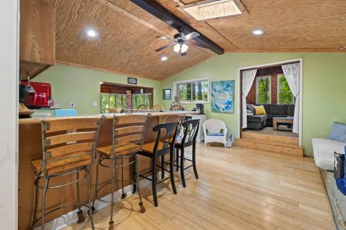 a kitchen and living room with a bar with stools at Cozy waterfront cabin with fire pit in Old Hickory