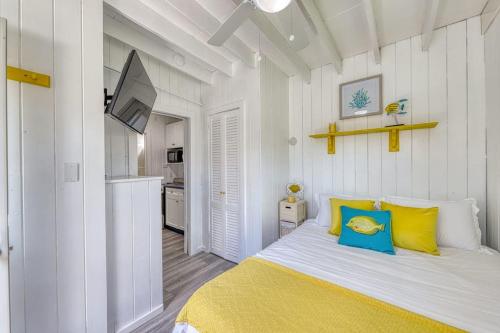 a bedroom with a bed with yellow and blue pillows at The Surfcomber Unit 1 in Ocean Bay Park