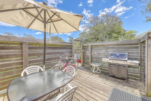 a wooden deck with a table and an umbrella at The Surfcomber Unit 1 in Ocean Bay Park