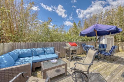 a patio with a blue couch and chairs and an umbrella at The Surfcomber Unit 3 in Ocean Bay Park