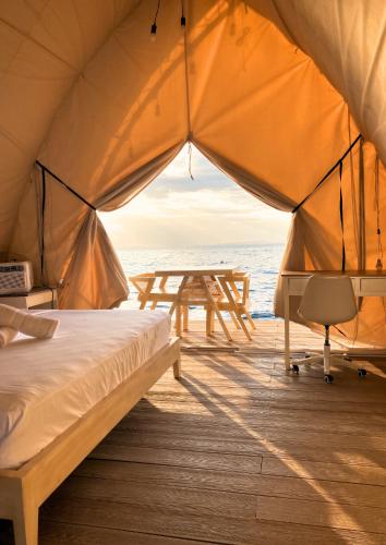 a tent with a picnic table on the beach at Reef Resort - Mount Apo View Unit B2 in Kaputian