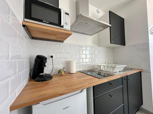 a kitchen with a wooden counter top and a microwave at Charmant studio in Plailly