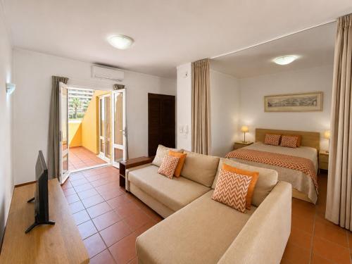 a bedroom with a bed and a couch in a room at Marina Plaza by Garvetur in Vilamoura