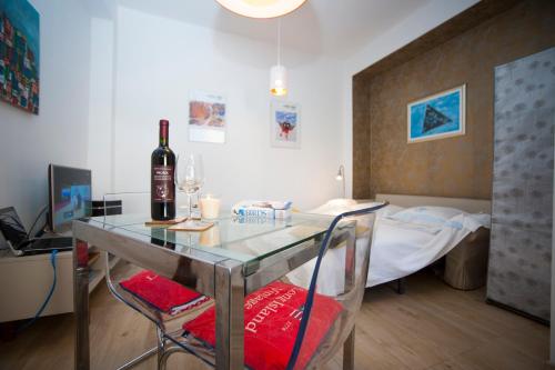 um quarto com uma mesa com uma garrafa de vinho e uma cama em Ayre Apartman Split em Split