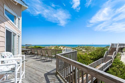 a deck with chairs and the ocean in the background at 1227 - Seven Shells in Corolla