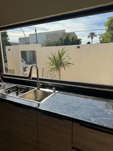 eine Küche mit Spüle und großem Fenster in der Unterkunft Casa Arce in Hermosillo