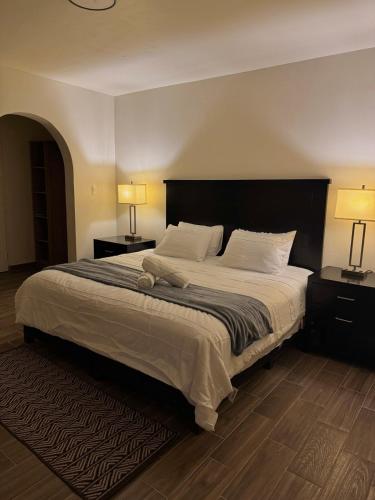 ein Schlafzimmer mit einem großen Bett und zwei Lampen in der Unterkunft Casa Arce in Hermosillo