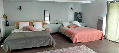 a bedroom with two beds with pillows at Gîtes avec piscine chauffée in Rosnay
